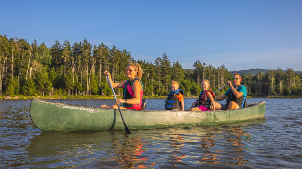 Family canoeing on Shavers Lake at Snowshoe Mountain